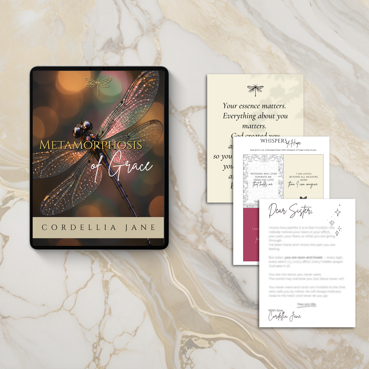 E-book titled 'Metamorphosis of Grace™' by Cordellia Jane on a marble surface with other printed materials.