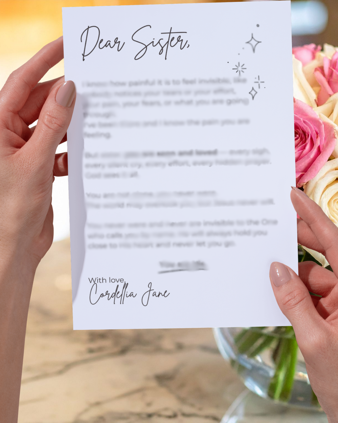 Letter held by hands with flowers in the background