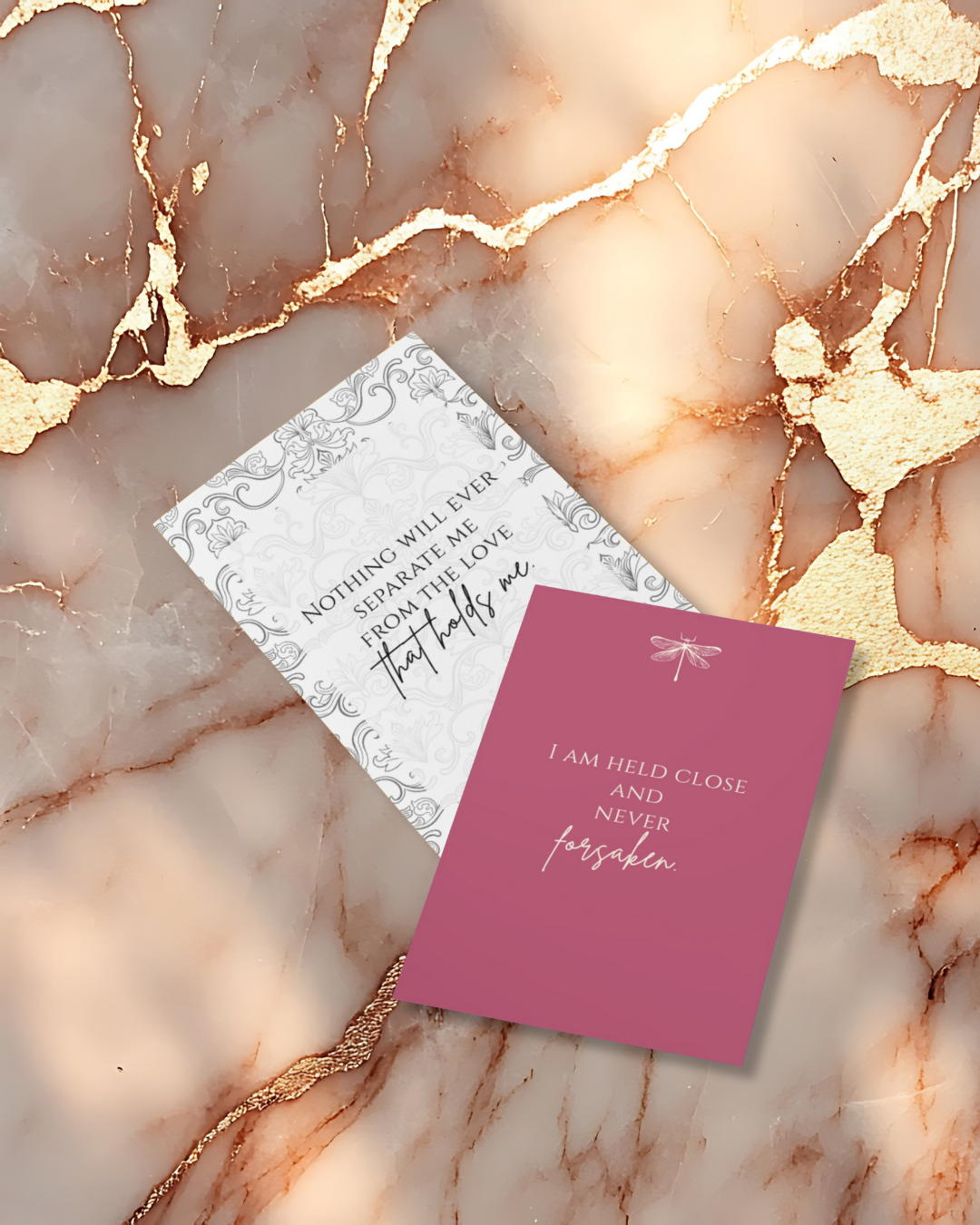 Two motivational cards on a marble surface with gold accents